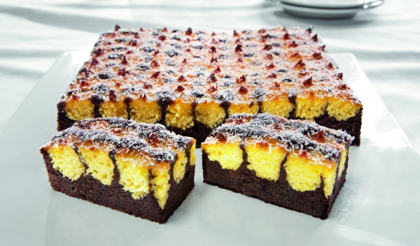 Jugosa masa tierna con chocolate y coco. Decorada con copos de coco y glaseada con gelatina neutra. ¡Un placer para el gourmet!