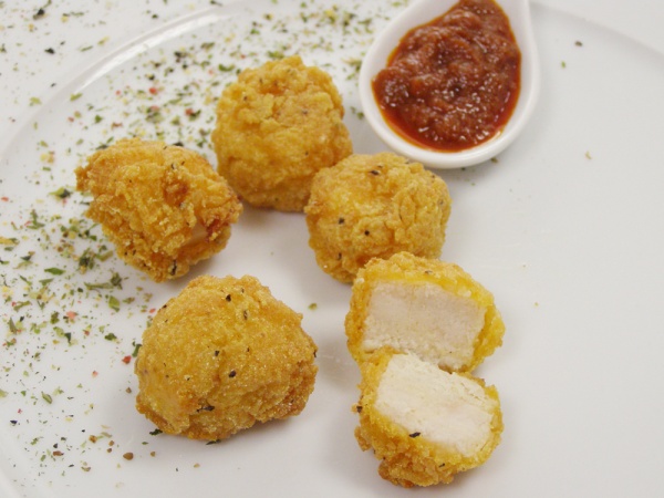 Palomitas de pollo elaboradas a partir de pechuga de pollo, rebozadas, empanadas y cocinadas. Listas para su regeneración y servicio.